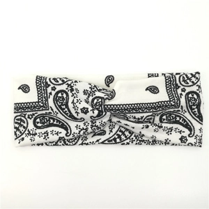 Detail view of a white twist headband featuring a classic black paisley knit pattern