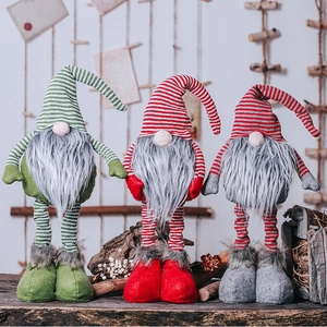Three festive Christmas gnomes with striped hats and plush beards on a vintage wooden surface