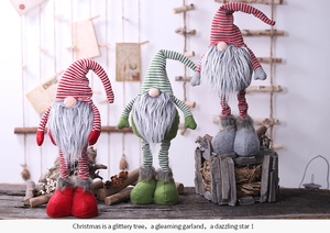 Detailed view of three Christmas gnomes with striped retractable legs and tall knit hats