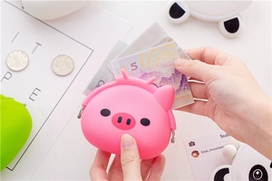 Close-up of pink pig silicone coin purse with metal clasp showing coin storage capacity