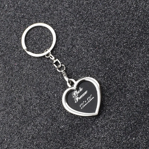 Macro shot of silver heart photo frame keychain with dimensions on black background