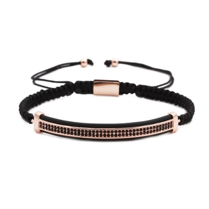 Detail of rose gold bar bracelet with double-row micro-set black stones on black woven cord
