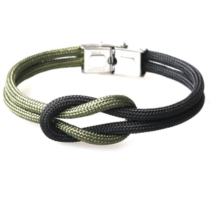 Detail of army green and black woven paracord bracelet with stainless steel buckle