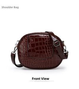 Detail of adjustable strap and embossed crocodile pattern on a deep red-brown mini backpack