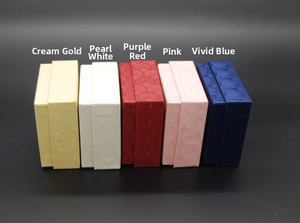 Detailed row of velvet jewelry gift boxes in cream, pearl, purple, pink, and royal blue