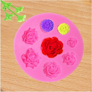 Detailed macro view of pink silicone rose mold with diverse floral cavities on wood base