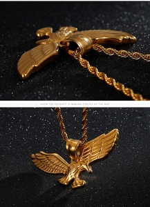 Detailed macro view of the golden eagle pendant and twisted rope chain on black surface