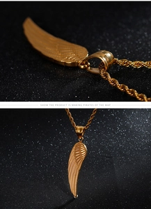 Macro detail of gold feather pendant with rope chain on shimmering black background