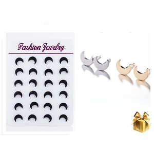 Detail of crescent moon earrings in black, gold and silver finishes on display card