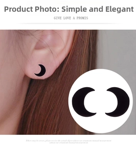 Close-up detail of black crescent moon stud earrings with a minimalist matte finish