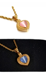 Détail d'un pendentif cœur vintage avec pierres roses et bleues sur chaîne dorée