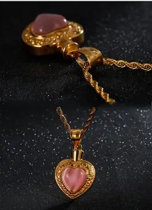 Détail du pendentif cœur doré avec pierre rose et filigrane sur chaîne torsadée
