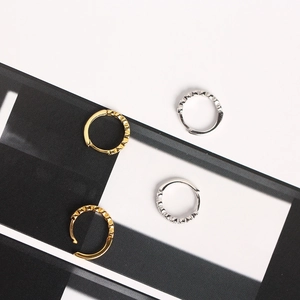 Detailed view of textured S925 sterling silver hoop earrings in gold and silver finishes