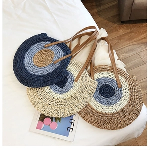 Trois variantes de sacs à bandoulière ronds tissés en paille bleu et beige pour plage