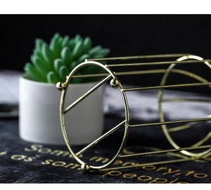 Macro shot of Nordic style golden metal cylinder storage rack with elegant ball feet