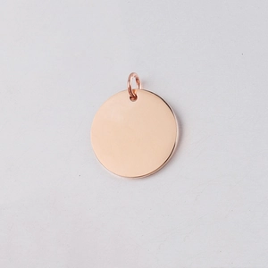 Macro shot of mirror-polished rose gold stainless steel round charm with jump ring