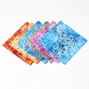 Colorful paisley cotton bandanas in red, blue, and yellow neatly stacked on white background