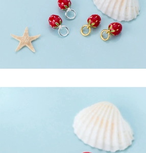 Macro shot of S925 silver enamel strawberry charms for DIY jewelry making with gold hooks