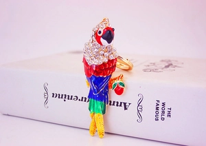 Macro shot of colorful rhinestone parrot keychain with red fruit charm on a book