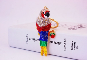 Close-up of colorful enamel parrot keychain with rhinestones on a golden metal base