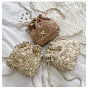 Detailed view of floral embroidered woven bucket bags in brown, khaki and beige colors