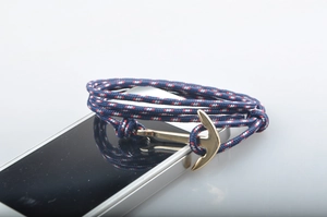 Gros plan du bracelet nautique tissé à la main avec fermoir ancre dorée détaillé