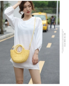 Detailed texture of bright yellow crescent straw bag with stylish round handle