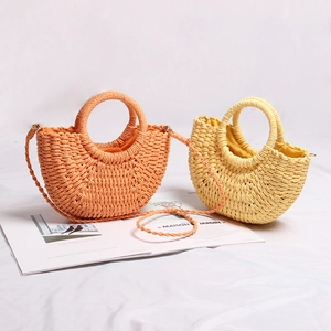 Detail of mini straw handbags in orange and yellow with woven handles and straps