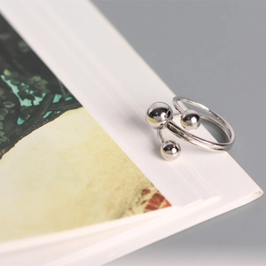 Macro shot of silver anxiety ring with three sliding beads on a minimalist book edge