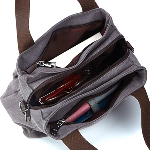 Grey canvas multi-compartment tote bag with brown straps and spacious interior storage