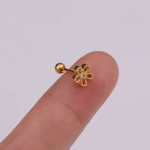 Gold flower stud earring with zircon center and screw back closure shown on ear