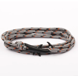 Close-up of gray woven rope bracelet featuring a black shark-shaped metal clasp