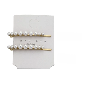 Detail view of 5.3cm long gold hair clips with white pearls and size specifications