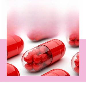 Macro view of a red transparent pill capsule filled with miniature red heart-shaped particles