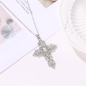 Detailed macro view of a silver-tone hollow cross necklace inlaid with white rhinestones