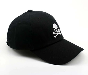 Close-up of white skull embroidery on black cotton baseball cap from a 45-degree angle