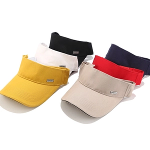 Multiple colors of sport sun visor hats with metal logo plates on white background