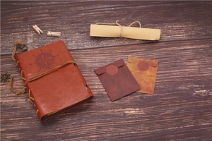 Flat lay of retro brown PU leather notebook with nautical compass and vintage envelopes