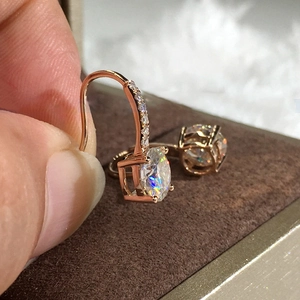 Macro detail of rose gold drop earrings featuring a large round cut zircon and pavé hook