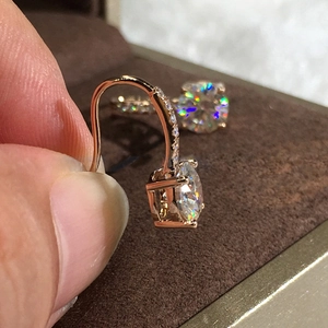 Detail of rose gold dangle earrings with sparkling round cubic zirconia stones