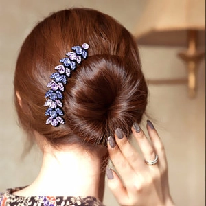 Detailed back view of a model wearing a wavy rhinestone headband with purple and blue crystals