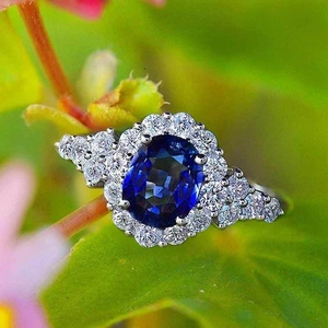 Anello di fidanzamento elegante con zircone blu ovale e pavé di diamanti su una foglia