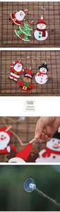 Detail of Christmas felt ornaments featuring Santa and elk with wooden clips and suction cups