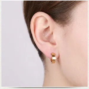 Polished gold stainless steel hoop earrings for men and women on a male model