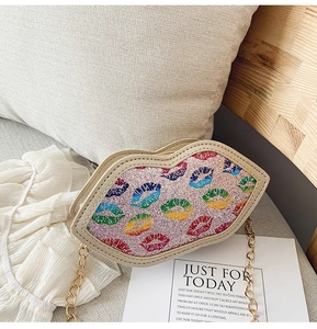 Close-up of pink glitter lip-shaped crossbody bag with rainbow pattern and gold chain