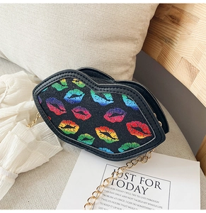 Close-up of glitter lip patterns and golden chain strap on a black kids crossbody bag