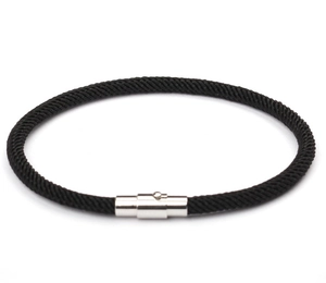 Close-up of black braided leather rope bracelet with a polished silver magnetic clasp