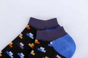 Close-up of colorful geometric patterns and purple heel on black cotton low-cut socks