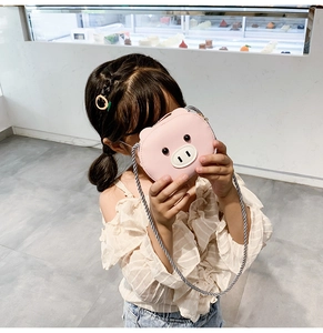 Pink pig crossbody bag detail showing cute cartoon animal design and woven shoulder strap