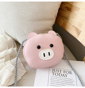 Detail of pink cartoon pig crossbody bag made of PU leather with woven rope shoulder strap